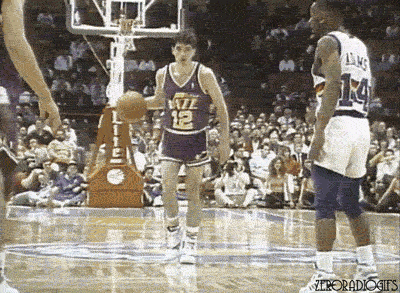 John Stockton passes the basketball to Karl Malone who dunks it.
