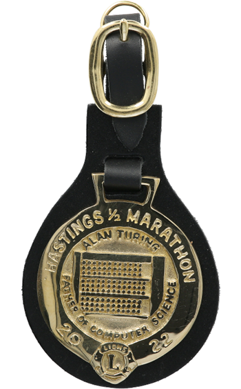 A finisher's medal for Hastings Half Marathon 2022, featuring an image of the Bombe code-breaking machine developed by Turing in the Second World War and the words father of computer science.